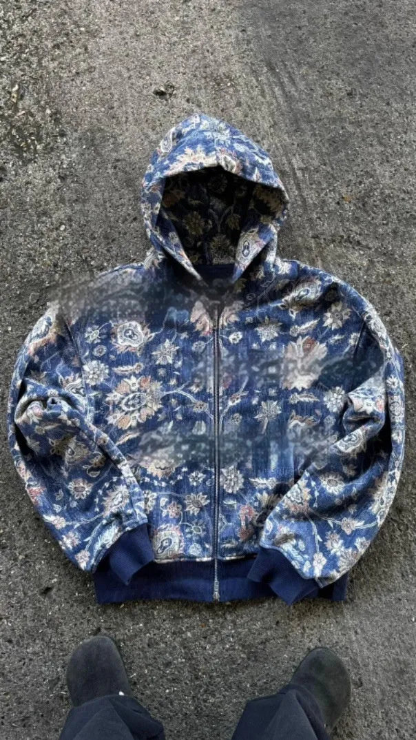 Man wearing a blue loose-fit zip-up hoodie with a hood, shown in a casual setting.