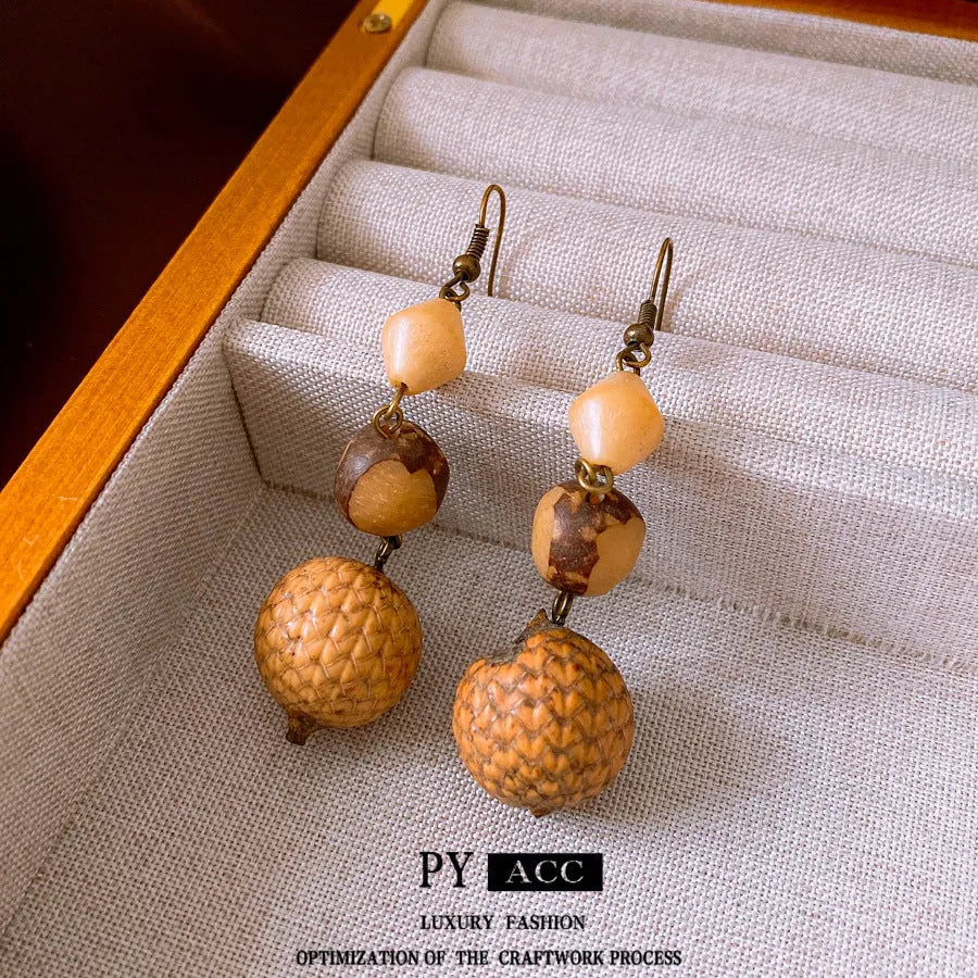 Retro ethnic style brown resin fruit core tassel earrings with geometric round design for women.