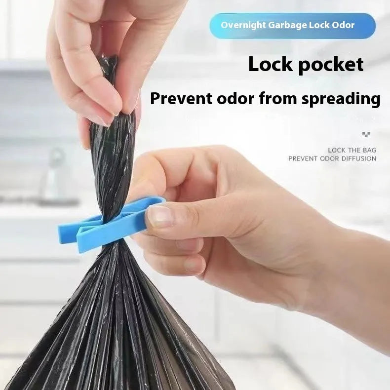A white polypropylene garbage bag fixing clip holding a black bin liner to the rim of a metal trash can.