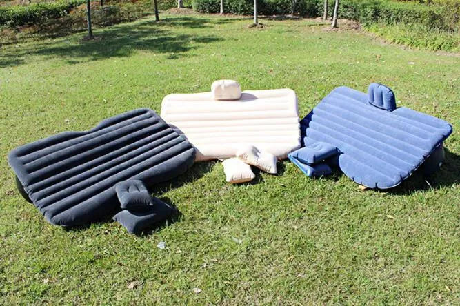 Black inflatable car bed with pillows, set up in the back of a five-seater car.