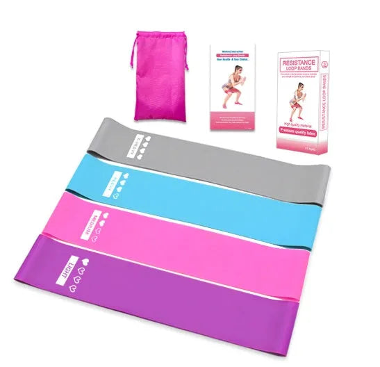 Four colour-coded resistance bands in purple, pink, blue, and grey with non-slip inner lines laid flat on a surface