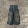Men's black denim shorts with cropped length and flame embroidery patches on the leg.