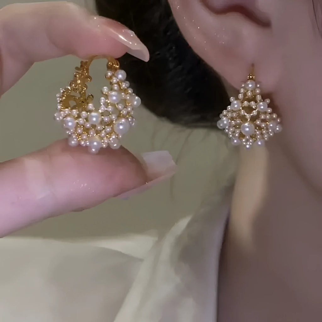 Gold-coloured copper flower basket earrings with white pearl inlay and small rice-shaped bead details.