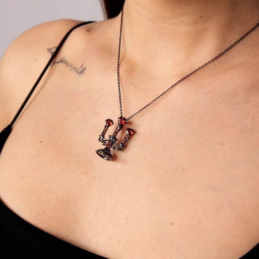 Close-up of a women's zinc alloy Gothic necklace with a hollow retro candlestick pendant on a cross chain.