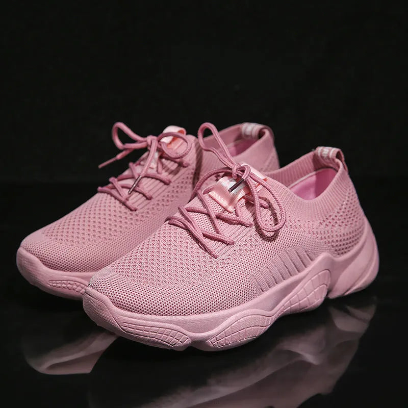 Women's white thick-soled woven trainers with front strap fastening on a plain background.