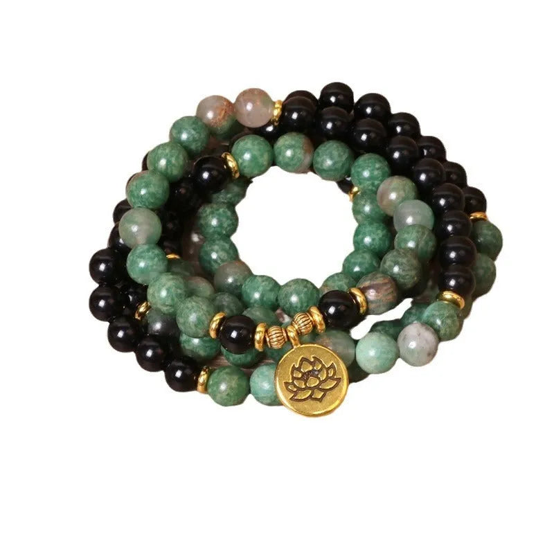 Green and black alloy bead elastic long bracelet on wrist.