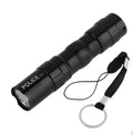 Black aluminium mini LED flashlight showing size next to a AA battery for scale.