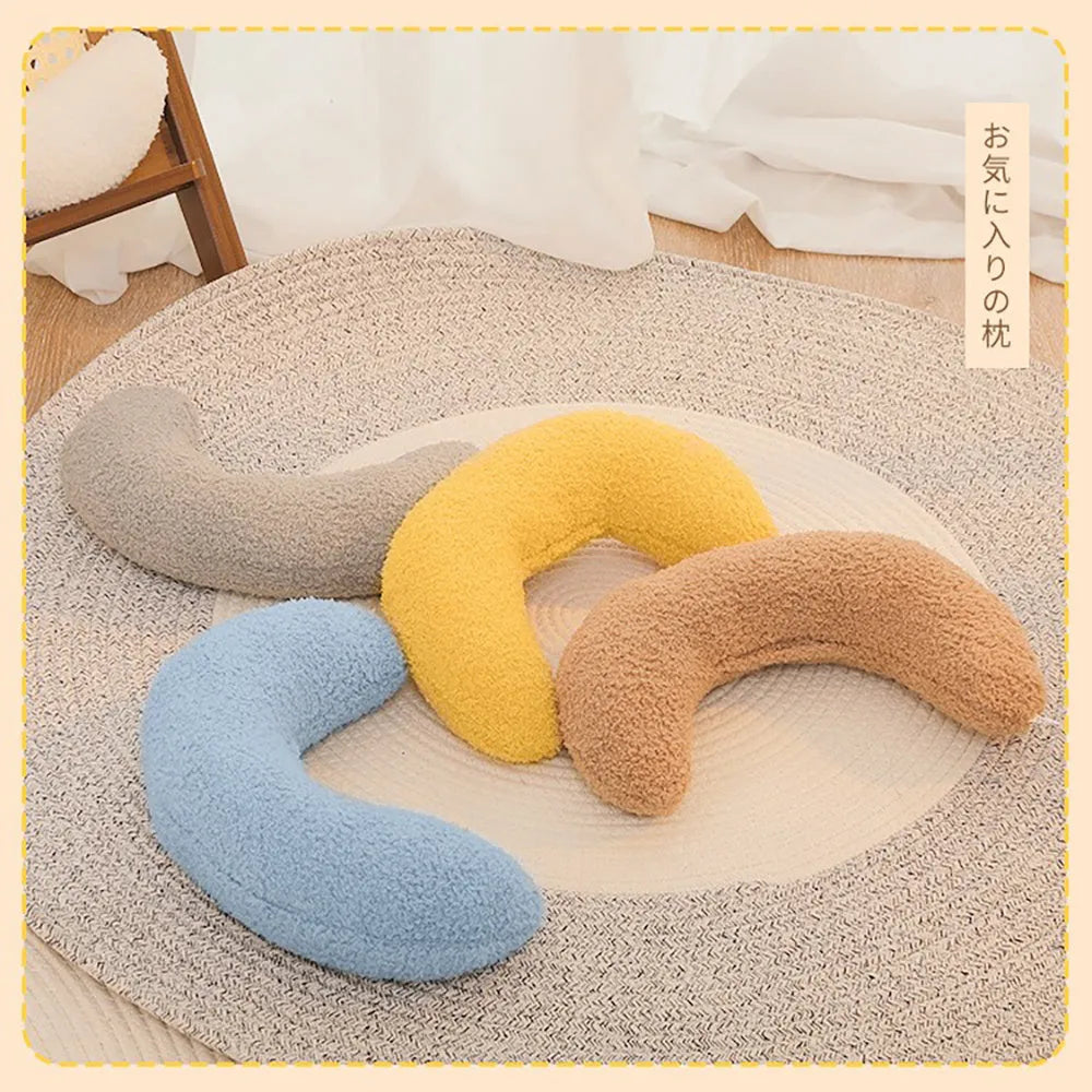 Blue U-shaped cat pillow with adjustable neck collar on sofa