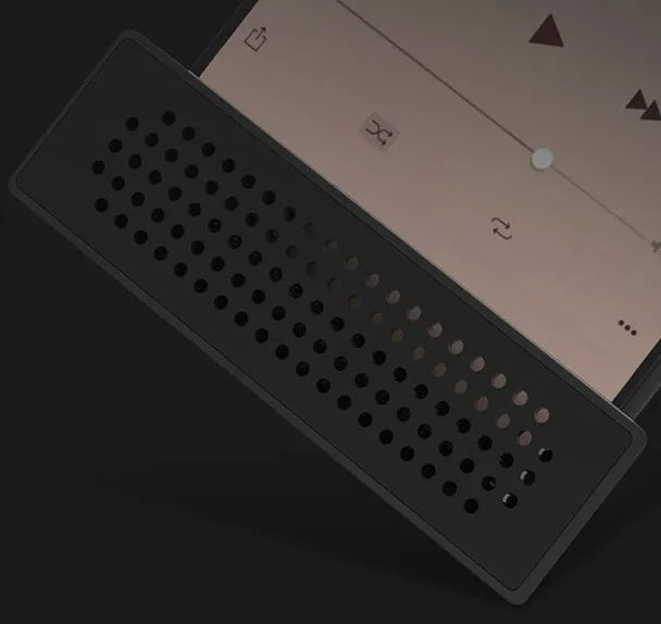 Portable black ABS plastic phone amplifier holder with an iPhone inserted, shown on a desktop.