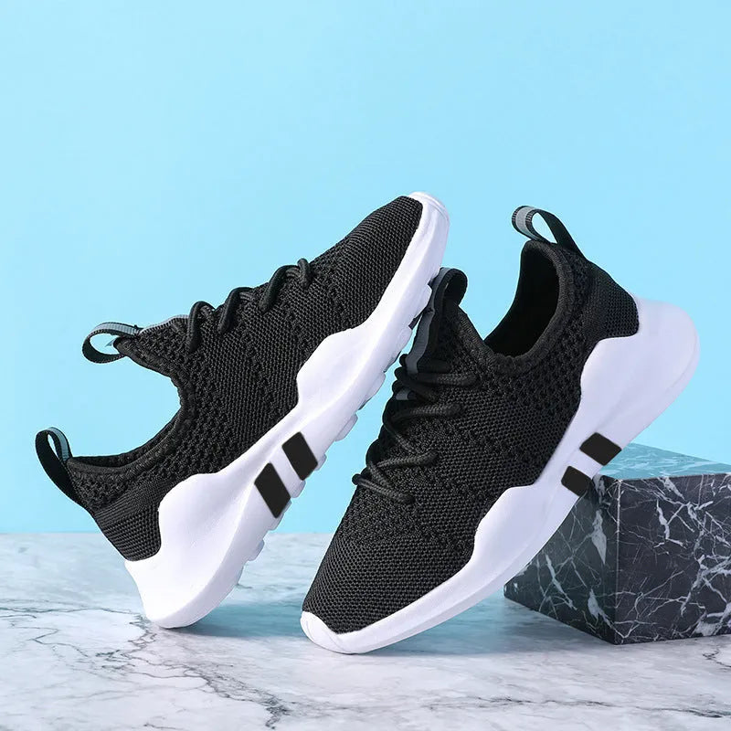 Breathable fly woven children's sports shoe in black with mesh upper and MD sole, side view