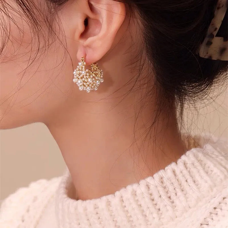 Gold-coloured copper flower basket earrings with white pearl inlay and small rice-shaped bead details.