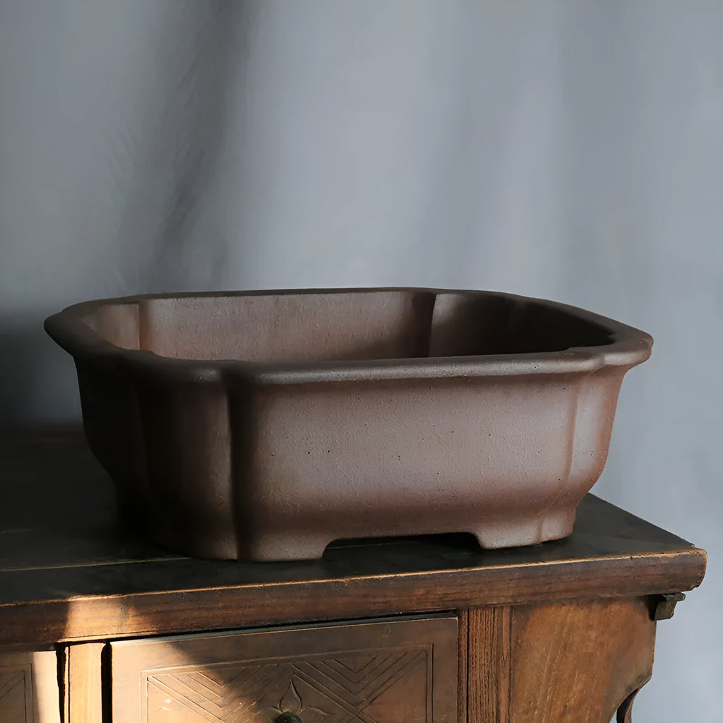 A modern rectangular flower pot made from purple sand ceramic, standing on a floor.