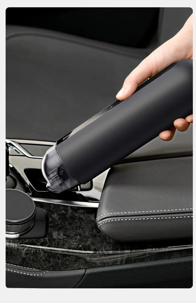 BASEUS wireless handheld car vacuum cleaner in black on a car seat, showing compact size and nozzle attachment.