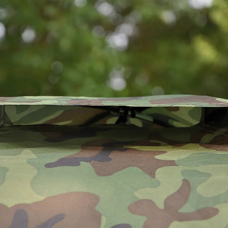 Green camouflage camping tent with triangular skylight, breathable mesh panels, and steel ground nails set up outdoors
