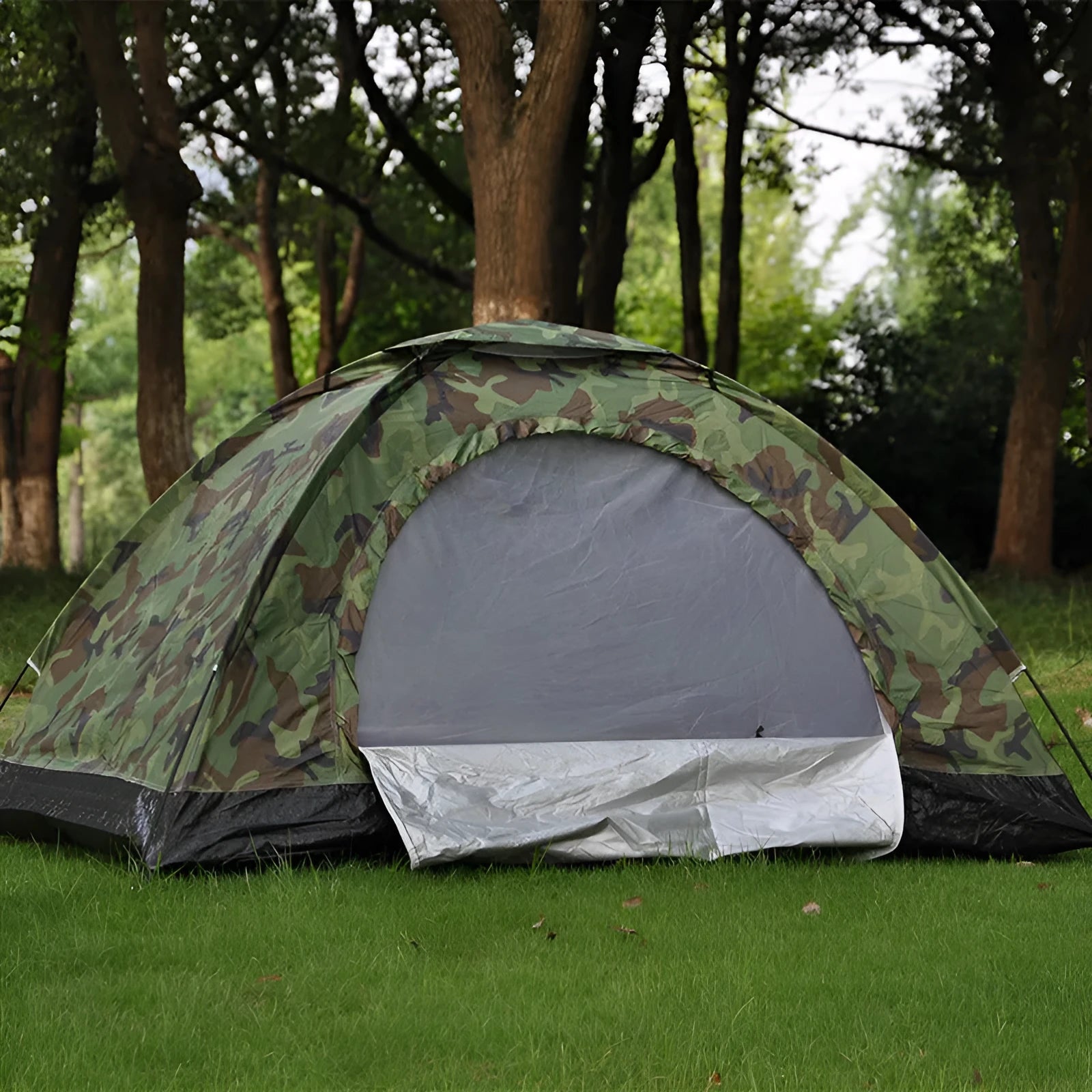 Green camouflage camping tent with triangular skylight, breathable mesh panels, and steel ground nails set up outdoors