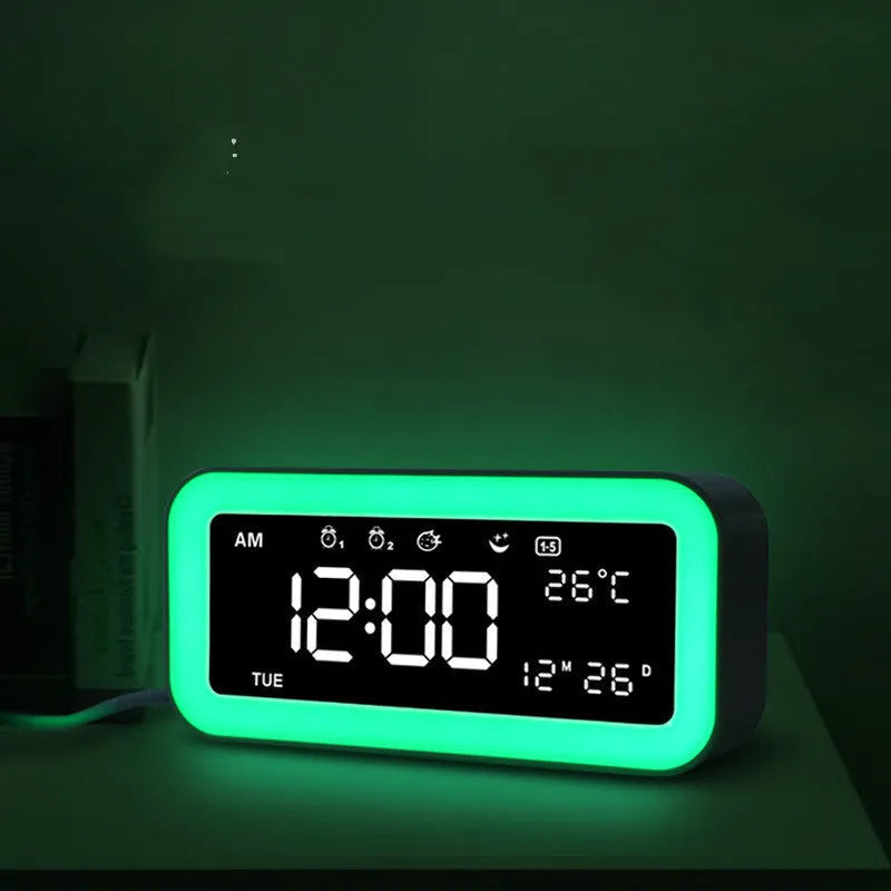 Blue rectangular LED digital alarm clock with atmosphere light on a bedside table.