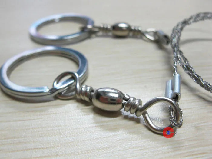 Survival wire saw tool with stainless steel blade and pull rings for outdoor cutting