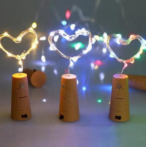 Silver wire LED string lights wrapped around wine bottle with warm white illumination
