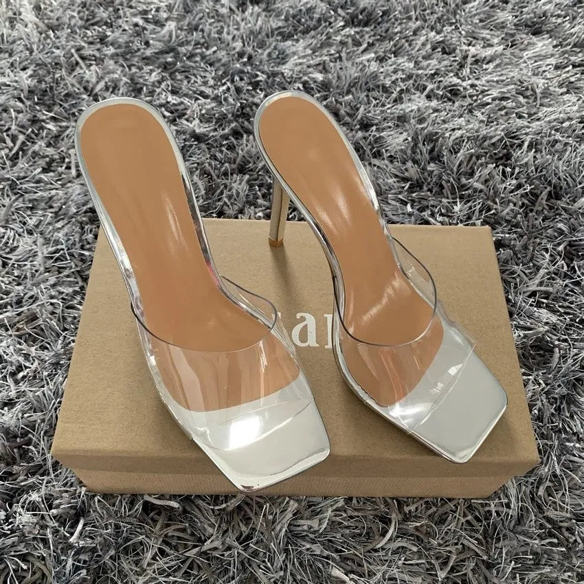 Women's black and silver high heel boots on a white background, showing the heel and boot design.