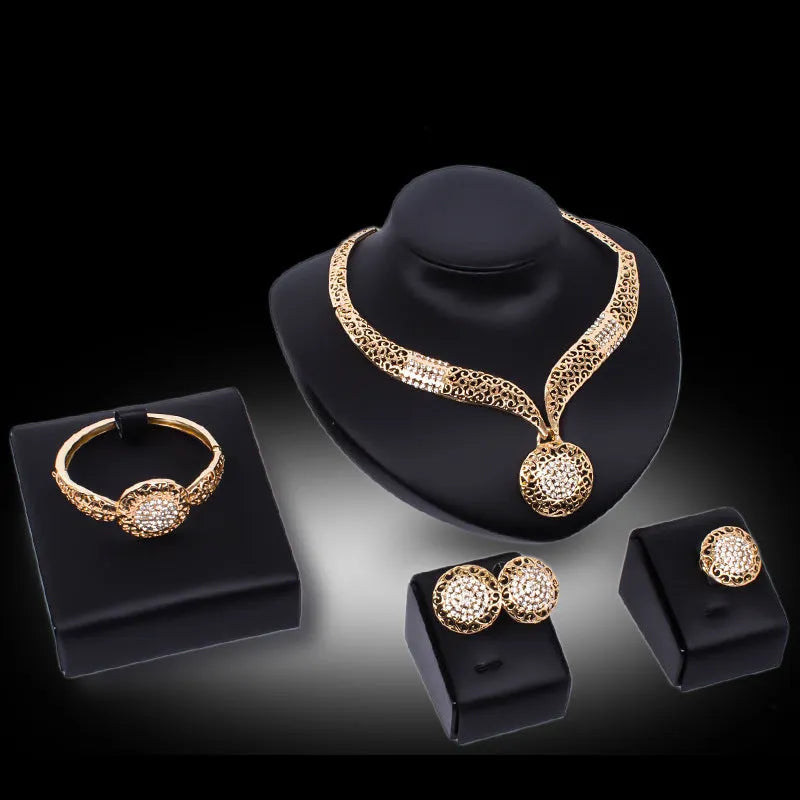 Gold jewellery four piece set with necklace, earrings, ring, and hand accessories featuring alloy and artificial gems