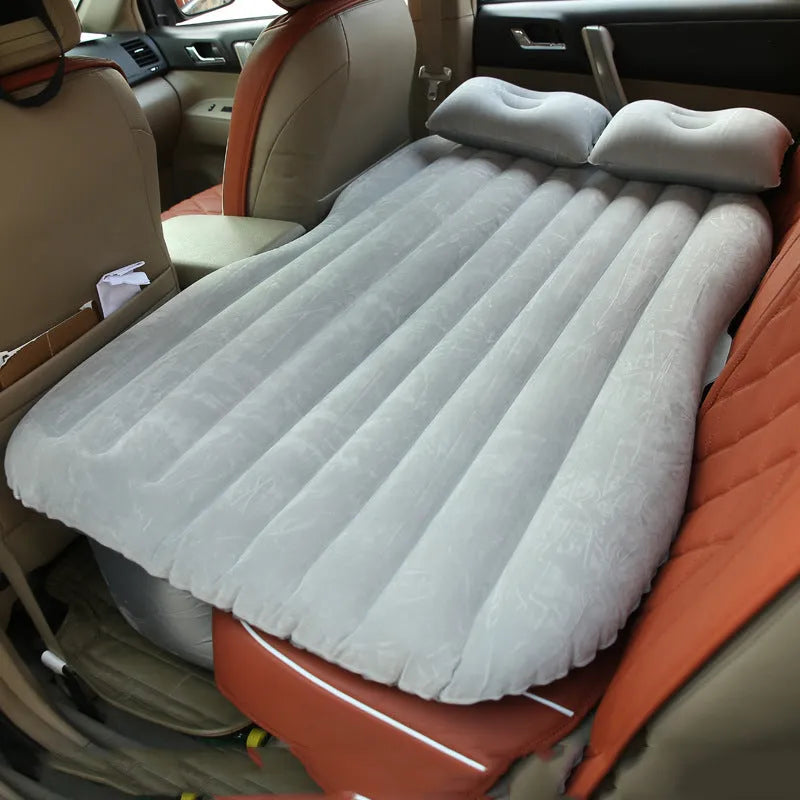 Black inflatable car bed with pillows, set up in the back of a five-seater car.