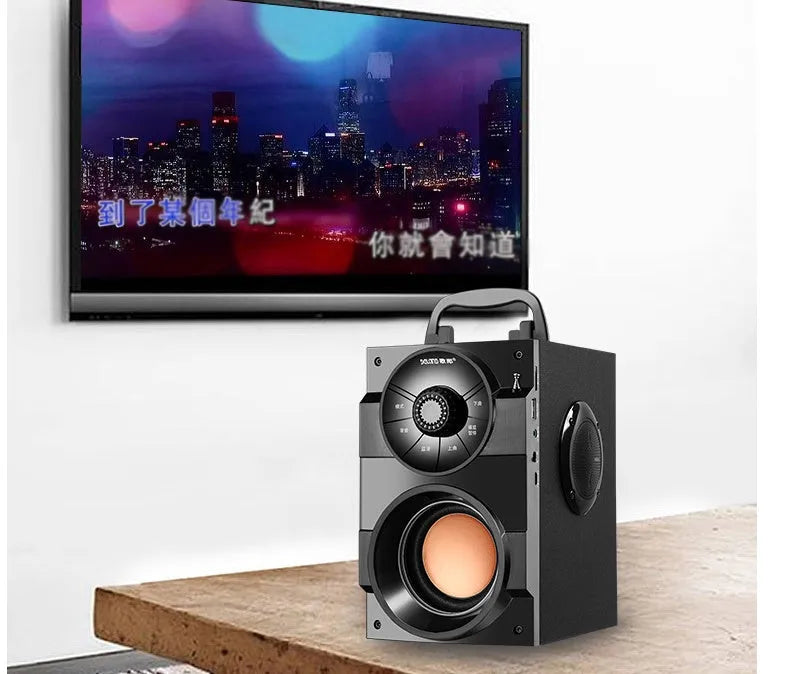 Black portable mini home audio system with subwoofer, 3.5mm audio cable, and USB charging cable.