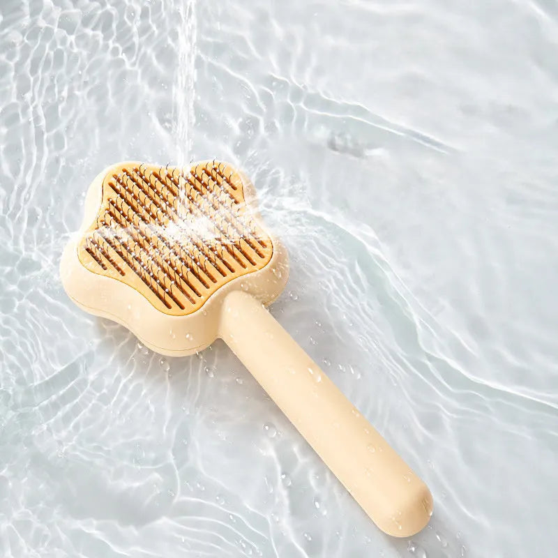 Green cat comb with stainless steel needles and self-cleaning magic wand function on white background