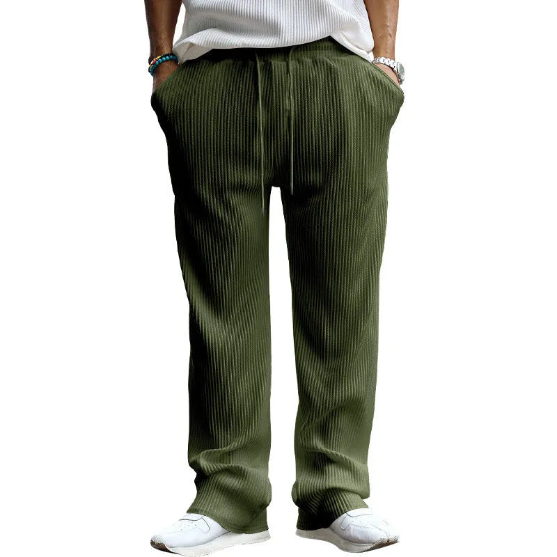 Man wearing loose-fitting straight leg casual trousers in army green, showing high waist and relaxed fit.