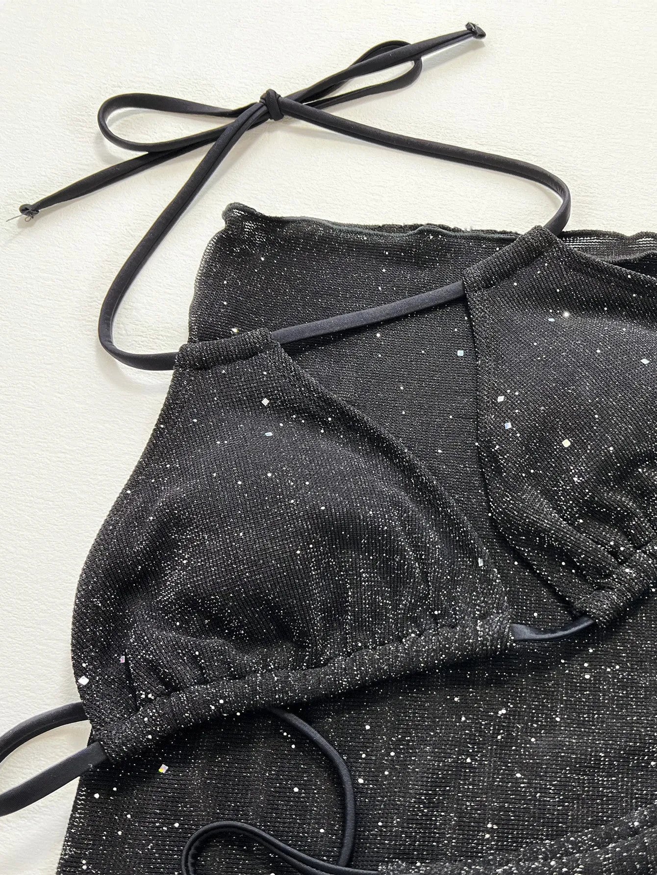 Black three-piece bikini swimsuit set with separate top and shorts