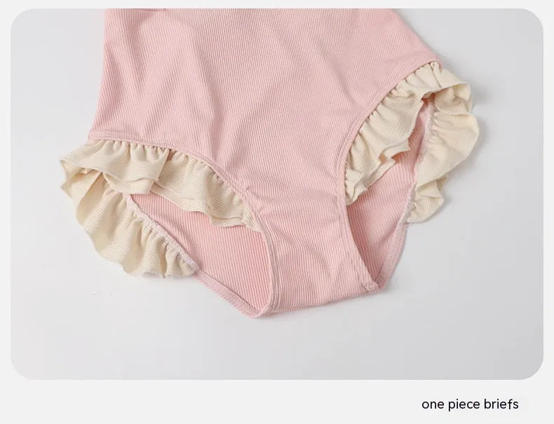 Pink women's conservative one-piece Siamese swimsuit on a hanger.