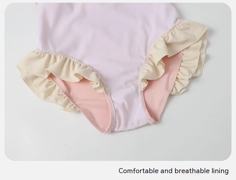 Pink women's conservative one-piece Siamese swimsuit on a hanger.