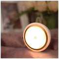 Round white motion sensor LED light unit with battery compartment, 80mm diameter.