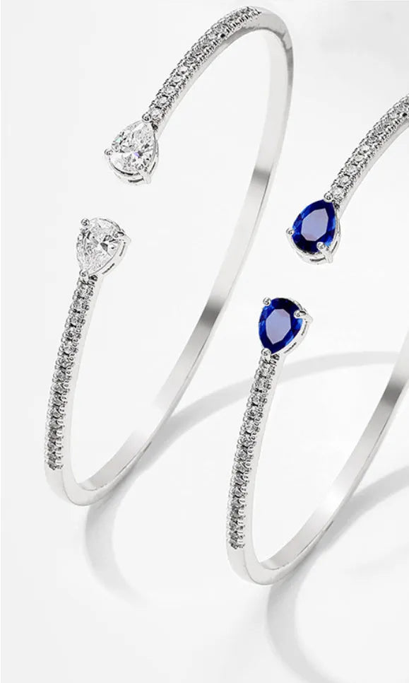 Copper bracelet with inlaid zircon stones in a simple style, shown in white and blue colour options.