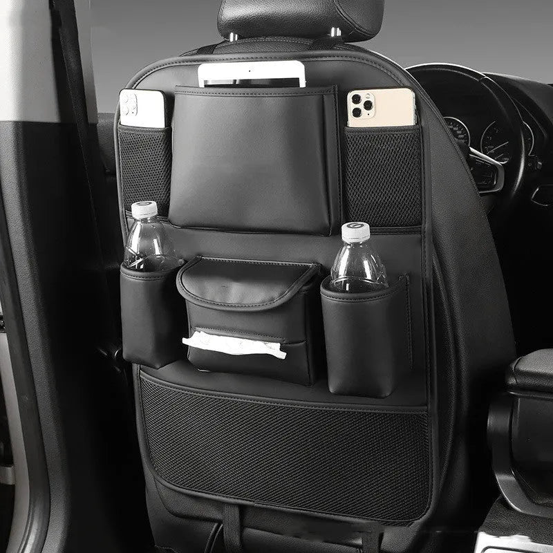 Black leather car seat back storage bag with pockets, shown suspended behind a car seat headrest.