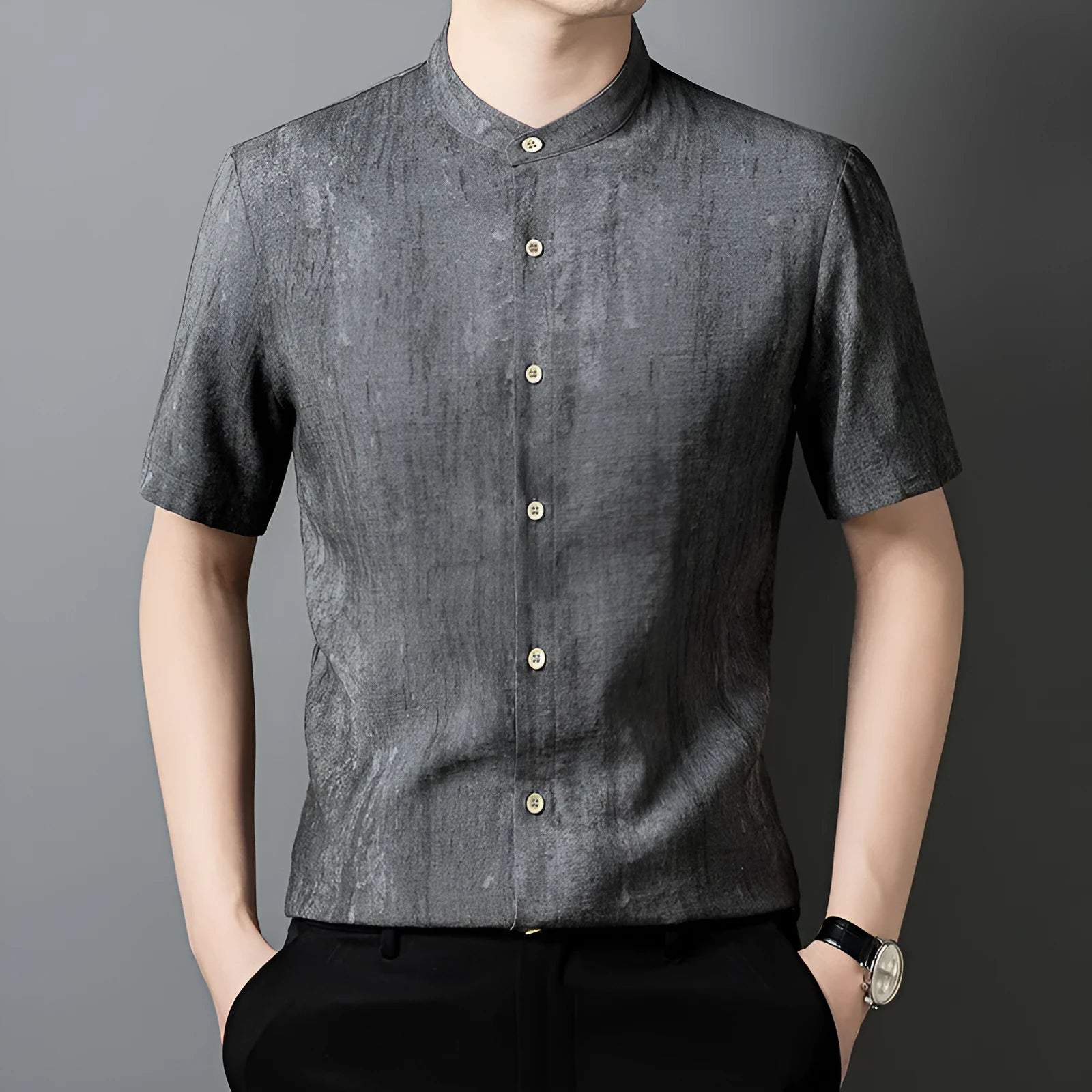 A man wearing a loose-fitting, short-sleeved casual shirt with a stand collar in a grey colour.