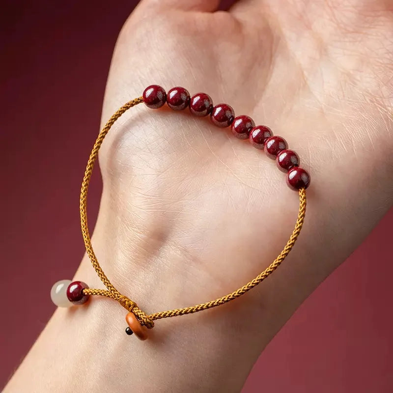 Hand-woven cinnabar and Hetian jade geometric bracelet on display
