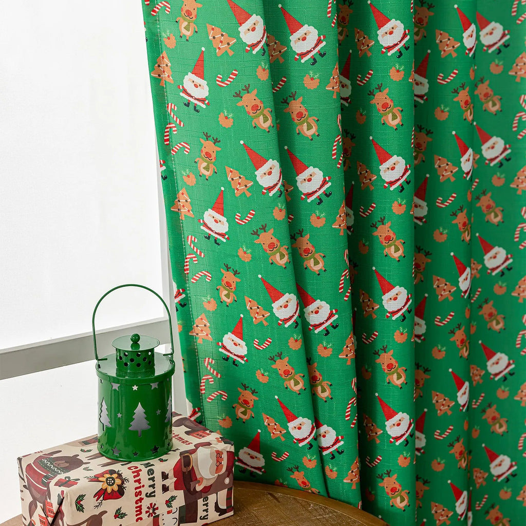 Green Christmas curtain with printed snowman and angel cartoon pattern, one metre wide.
