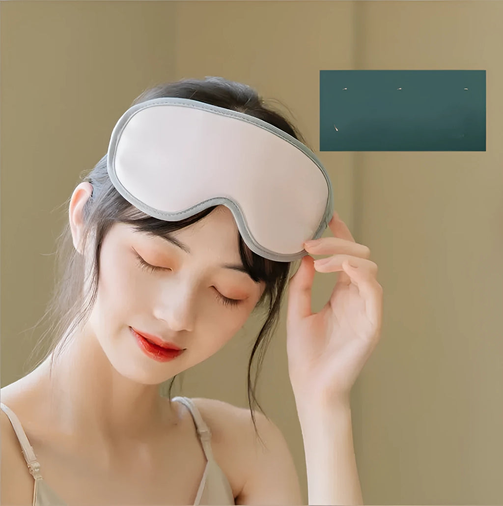 Pink and green portable USB-powered eye massage goggles with a suede shell on a grey background.