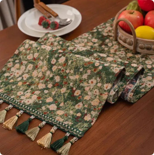 Long decorative table runner with tassels on a wooden dining table in a blue ginkgo leaf pattern.