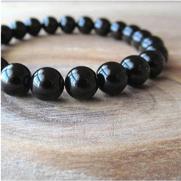 Black agate stretch bracelet with 8mm geometric beads on a black elastic cord.