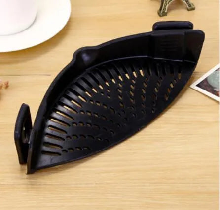 Silicone clip-on colander with stainless steel buckle attached to a pot, draining liquid, available in four colours.