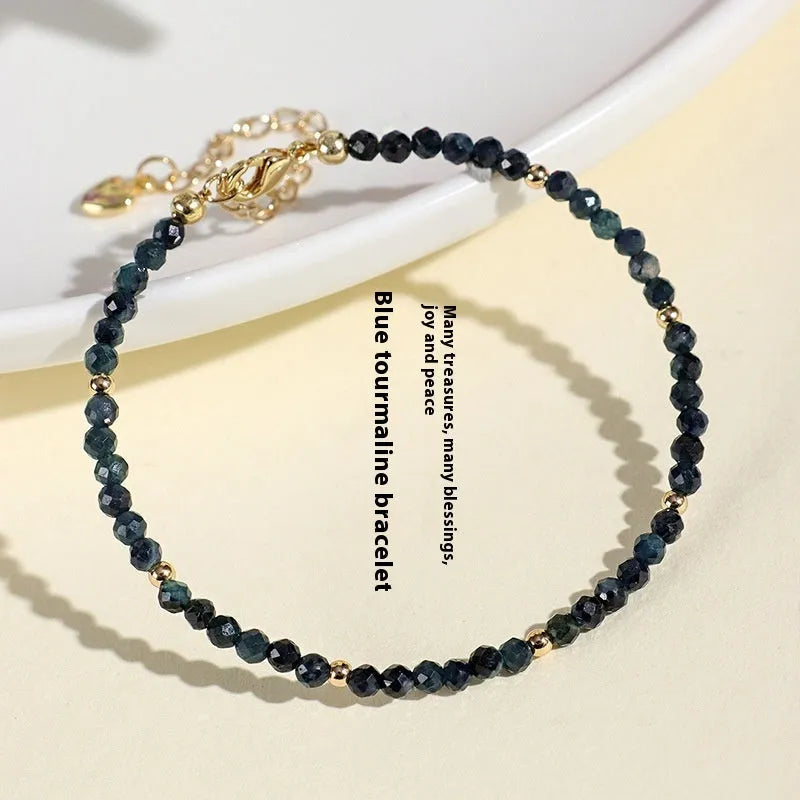 Close-up of a women's blue tourmaline bracelet with 3mm cut beads and spacer bead design.