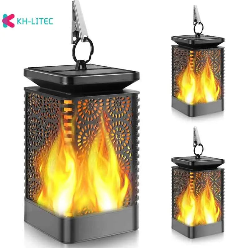 Set of four black solar-powered hanging flame torch lights for outdoor garden decoration.