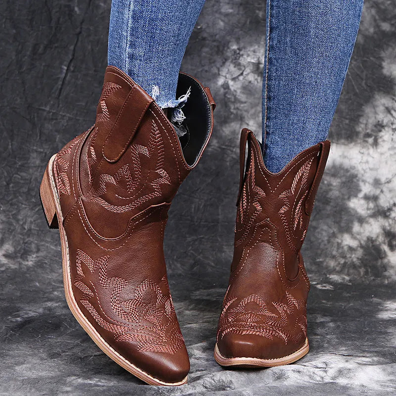 Women's blue embroidered cowboy ankle boots with a low wedge heel and pointed toe.