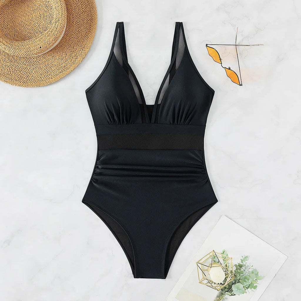 Black women's one-piece swimsuit with halter neck and mesh panel detailing.