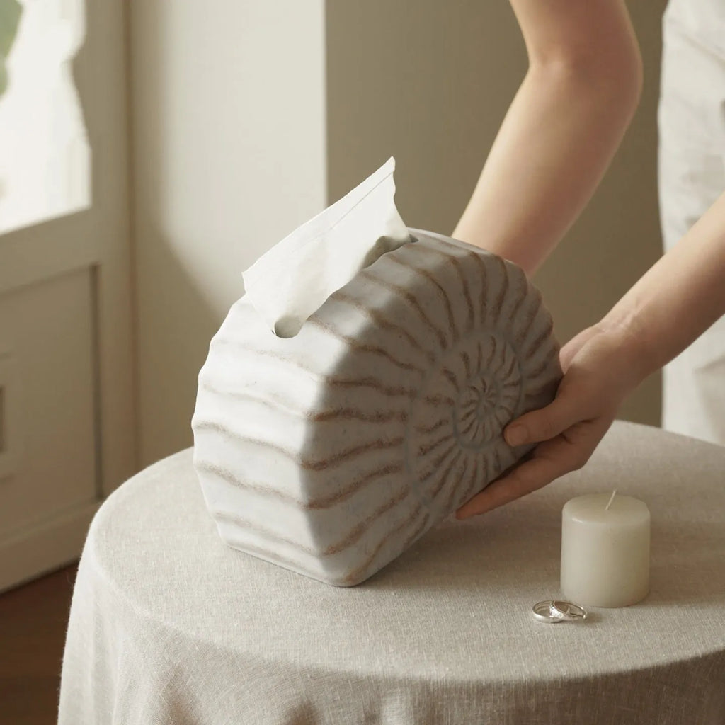 Modern conch ramble patterned resin decorative tissue box holder on a table.
