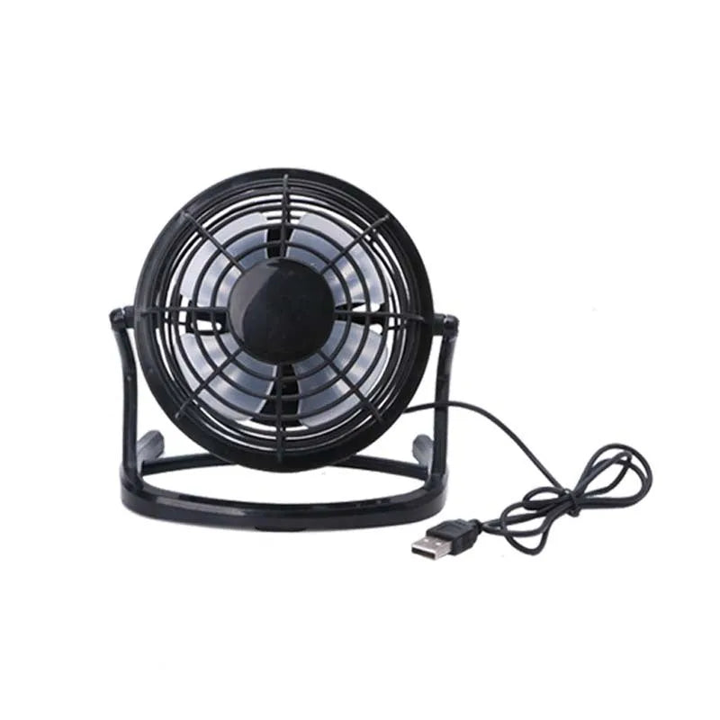 Mini adjustable USB desk fan in black on a desk next to a laptop