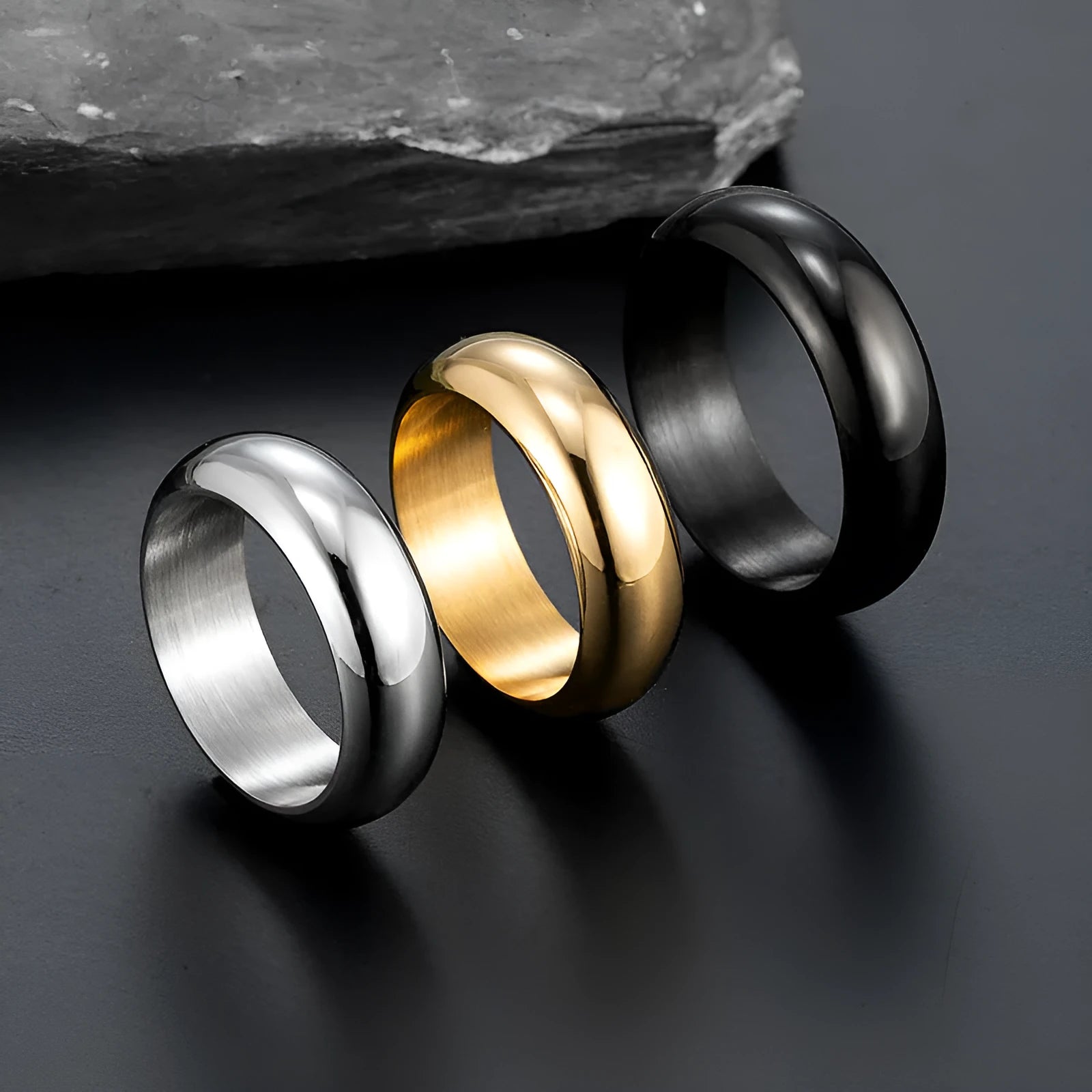 Glossy electroplated titanium steel ring shown in gold, black, and steel colour on a size chart