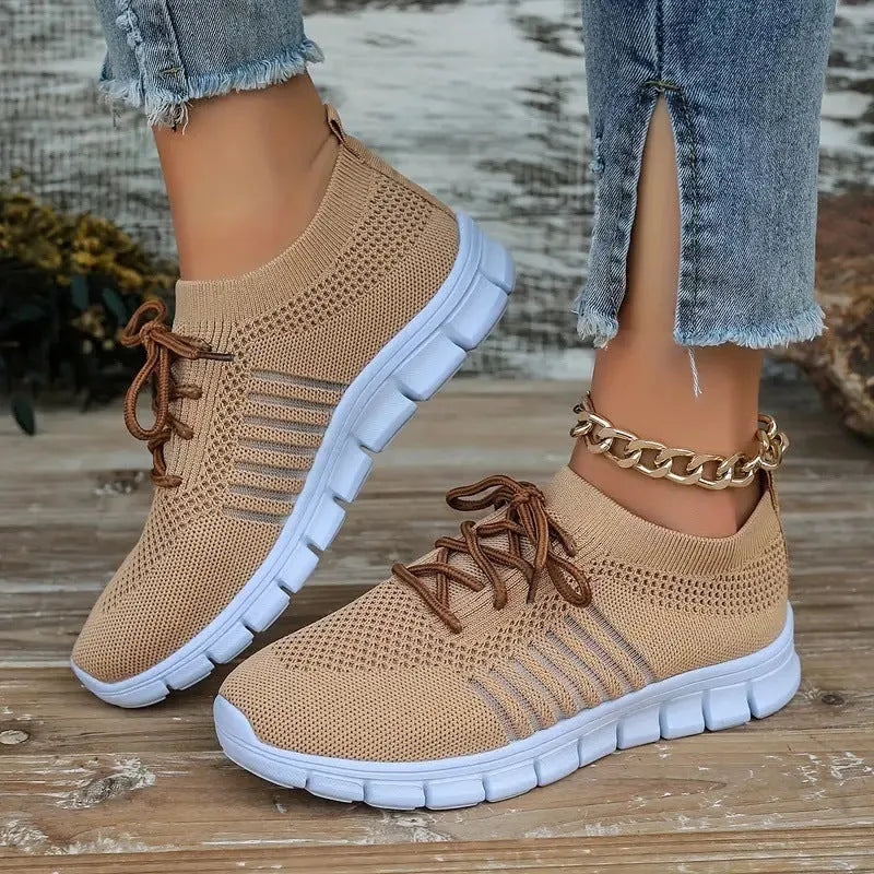 Casual ladies breathable flying knit sports flat shoes in black with mesh upper and front tie closure on foot