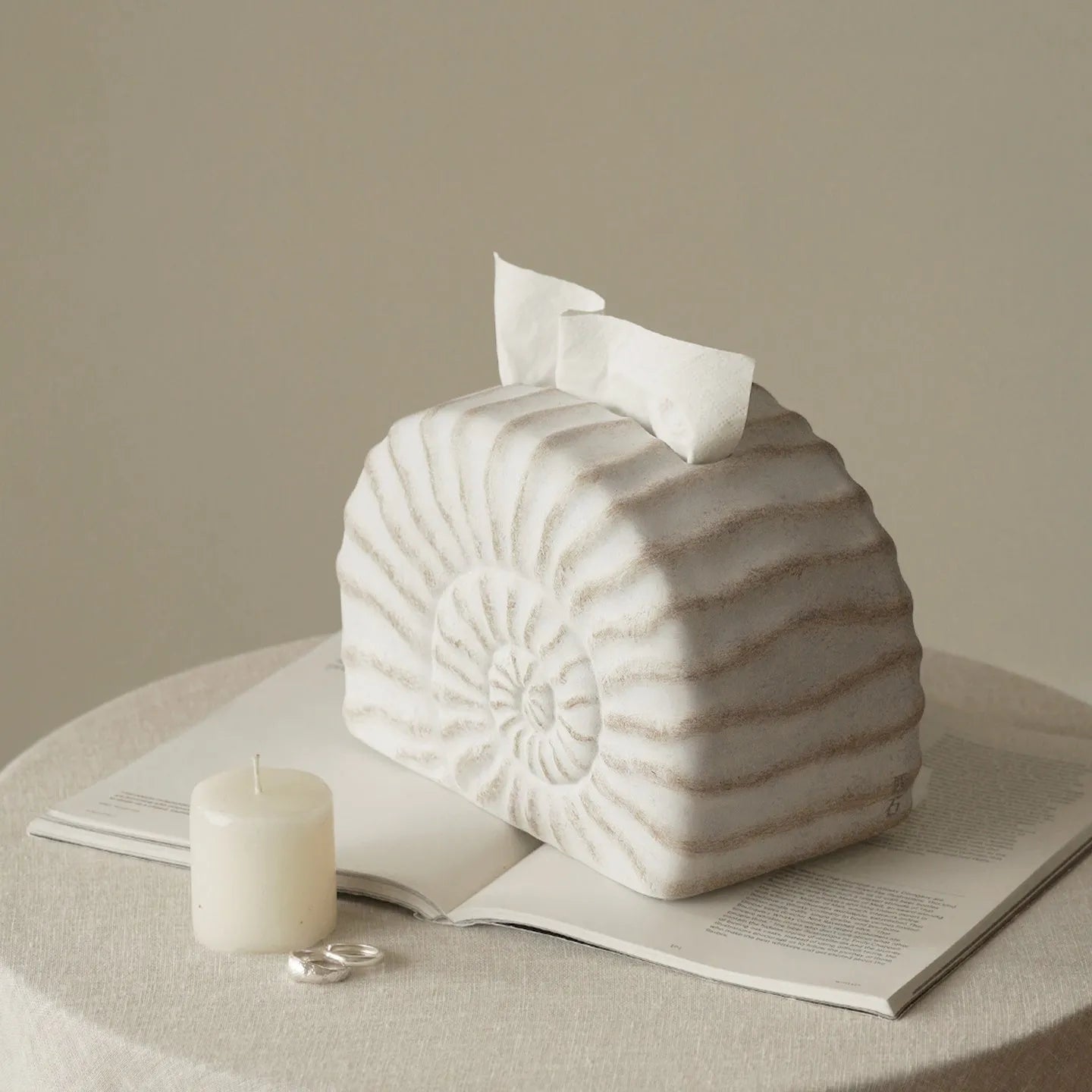 Modern conch ramble patterned resin decorative tissue box holder on a table.